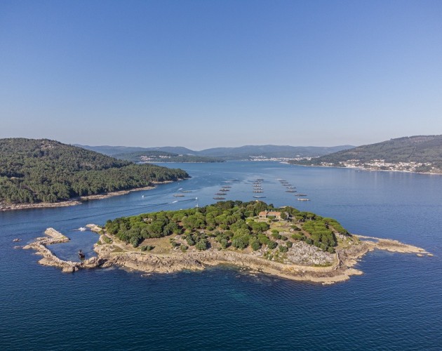 Vista aérea de Isla de A Creba, una isla privada en la ría de Muros y Noia, rodeada de aguas cristalinas y naturaleza, ideal par